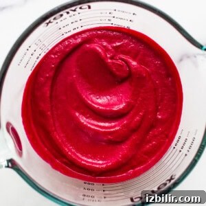 Beet puree in a measuring cup.