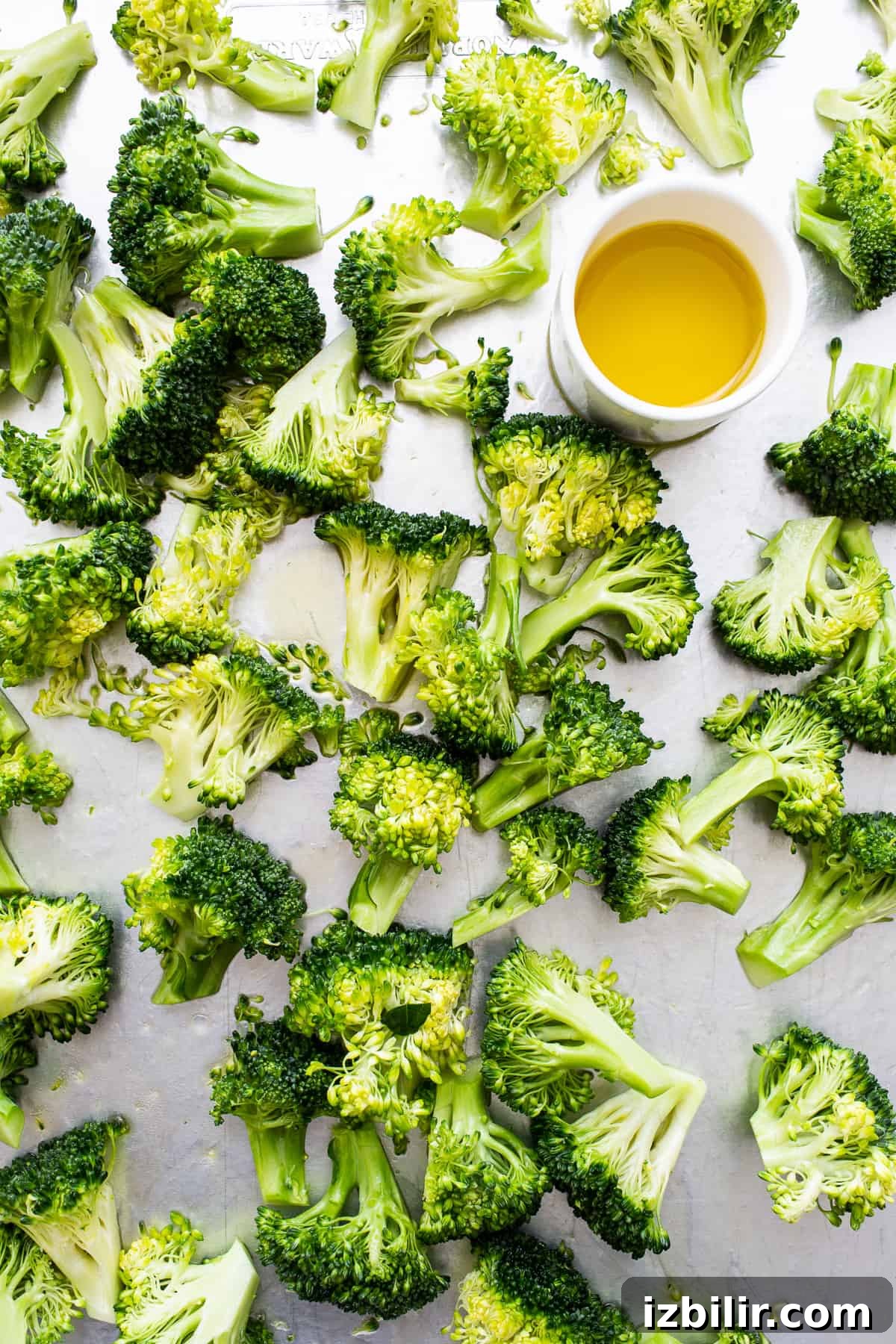 Broccoli florets and a bowl of olive oil.