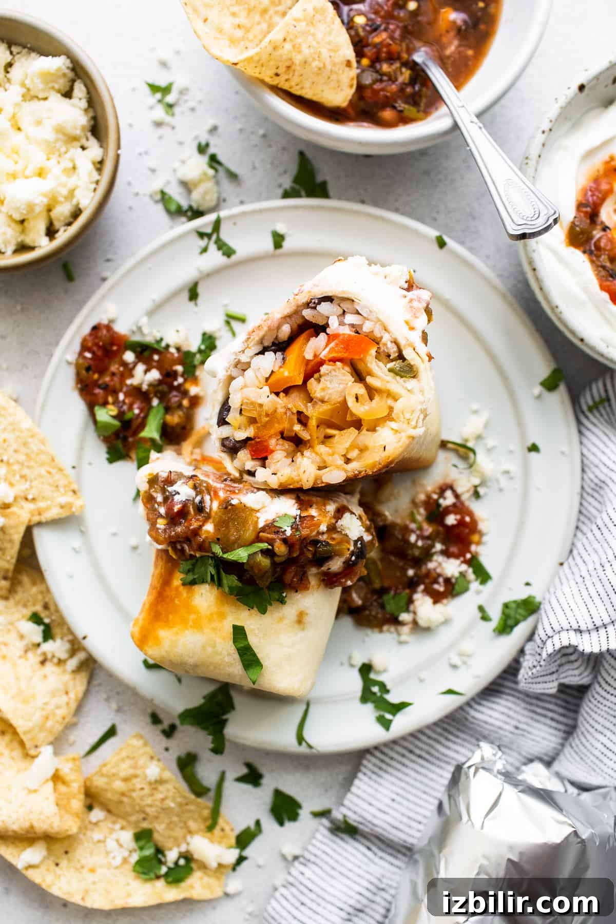 These chicken fajita burritos are filled with salsa chicken, fajita veggies, black beans, and rice. Yum! Chicken fajita burrito on a plate.