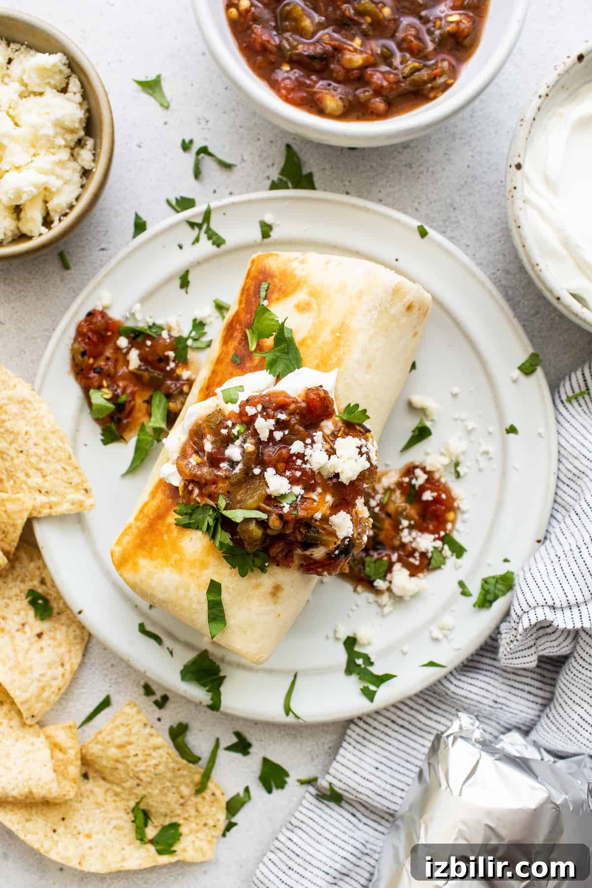 Chicken Fajita Burrito Recipe with Peppers and Onions 6 Chicken fajita burrito topped with salsa and sour cream.