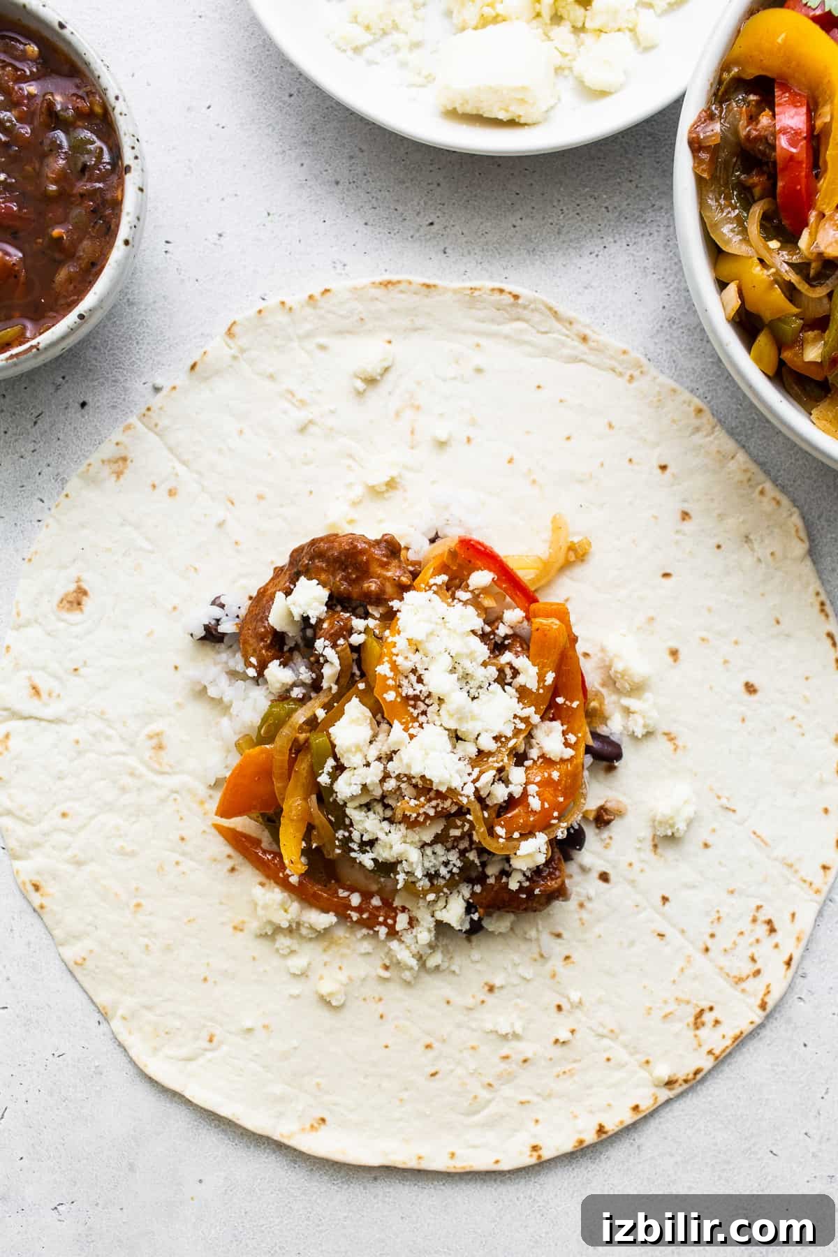 Chicken Fajita Burrito Recipe with Peppers and Onions 3 Chicken fajita ingredients on a burrito tortilla.