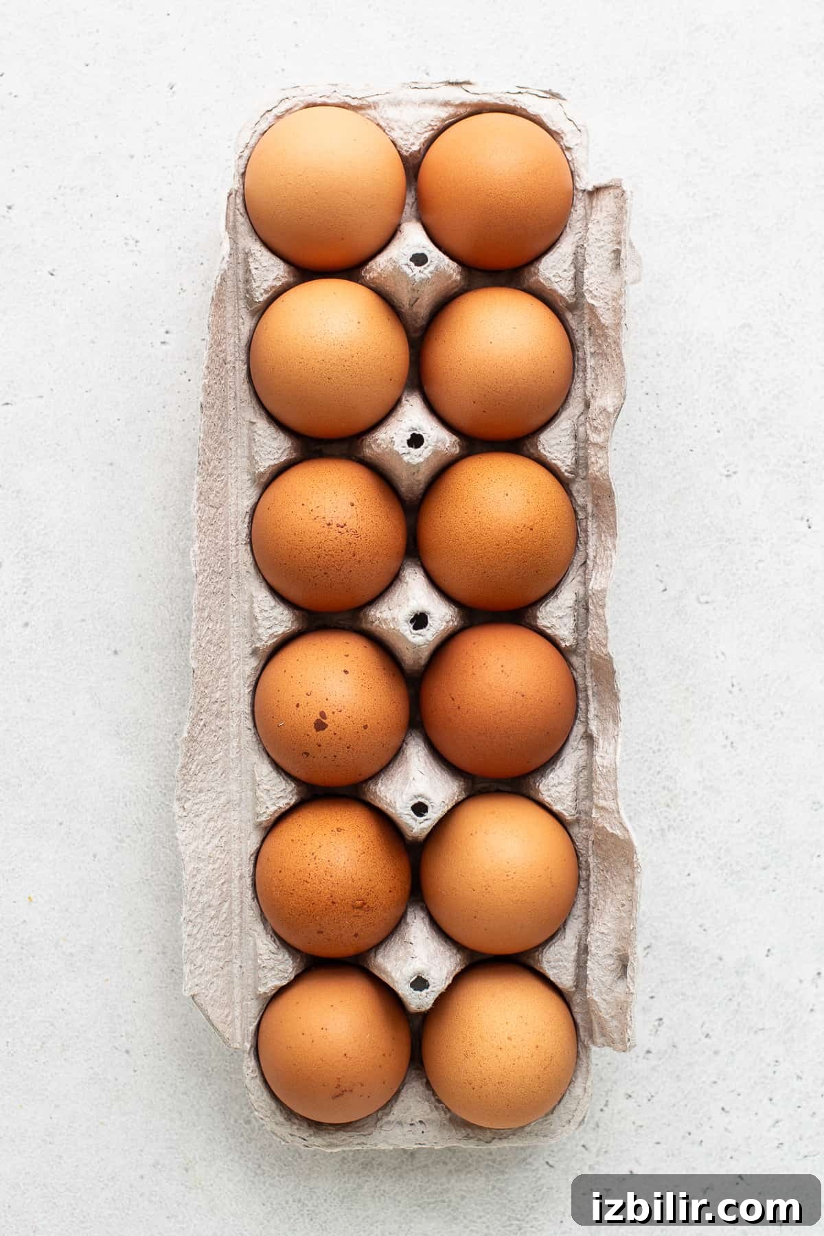 A dozen eggs in an egg carton.