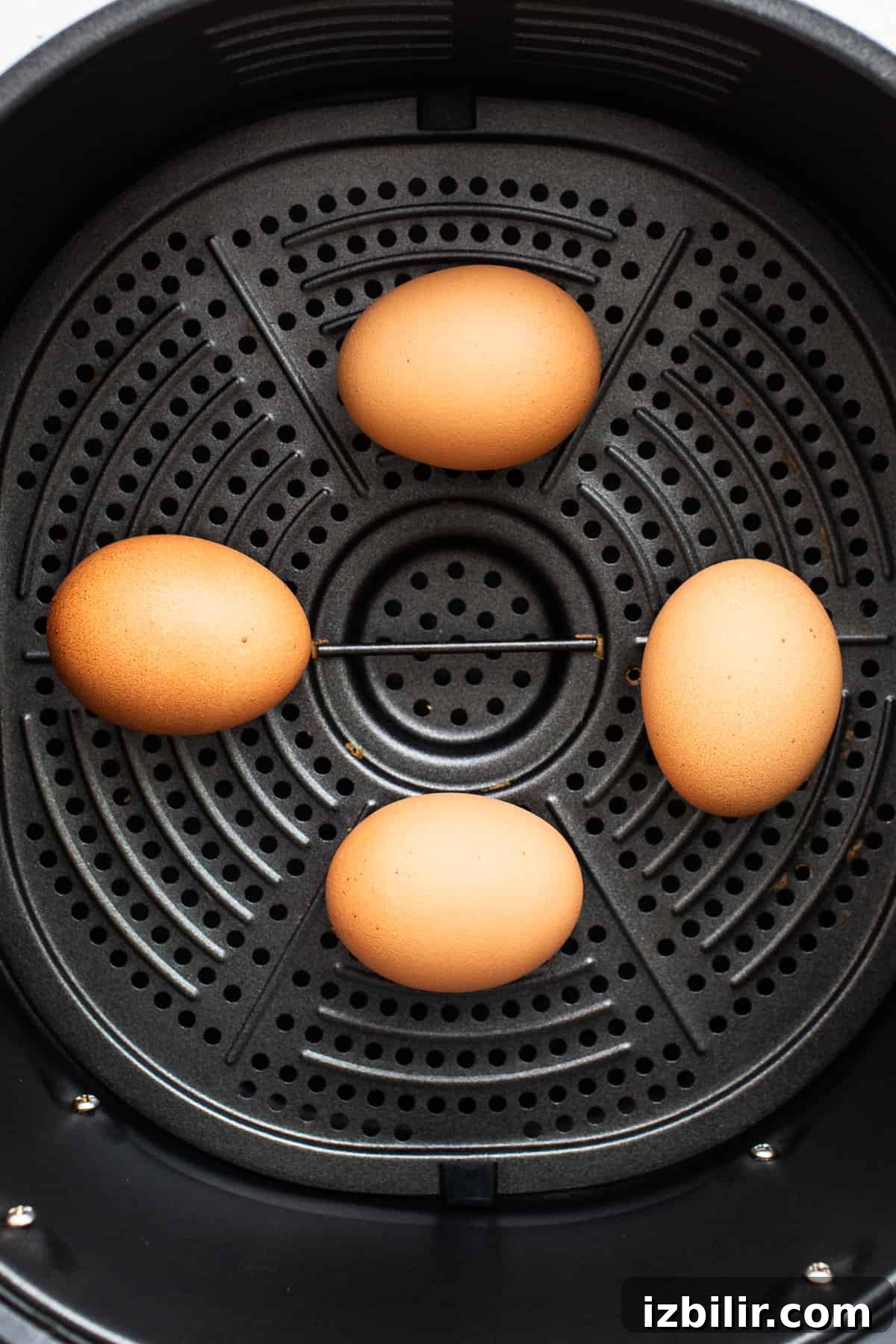 4 eggs in an air fryer basket.