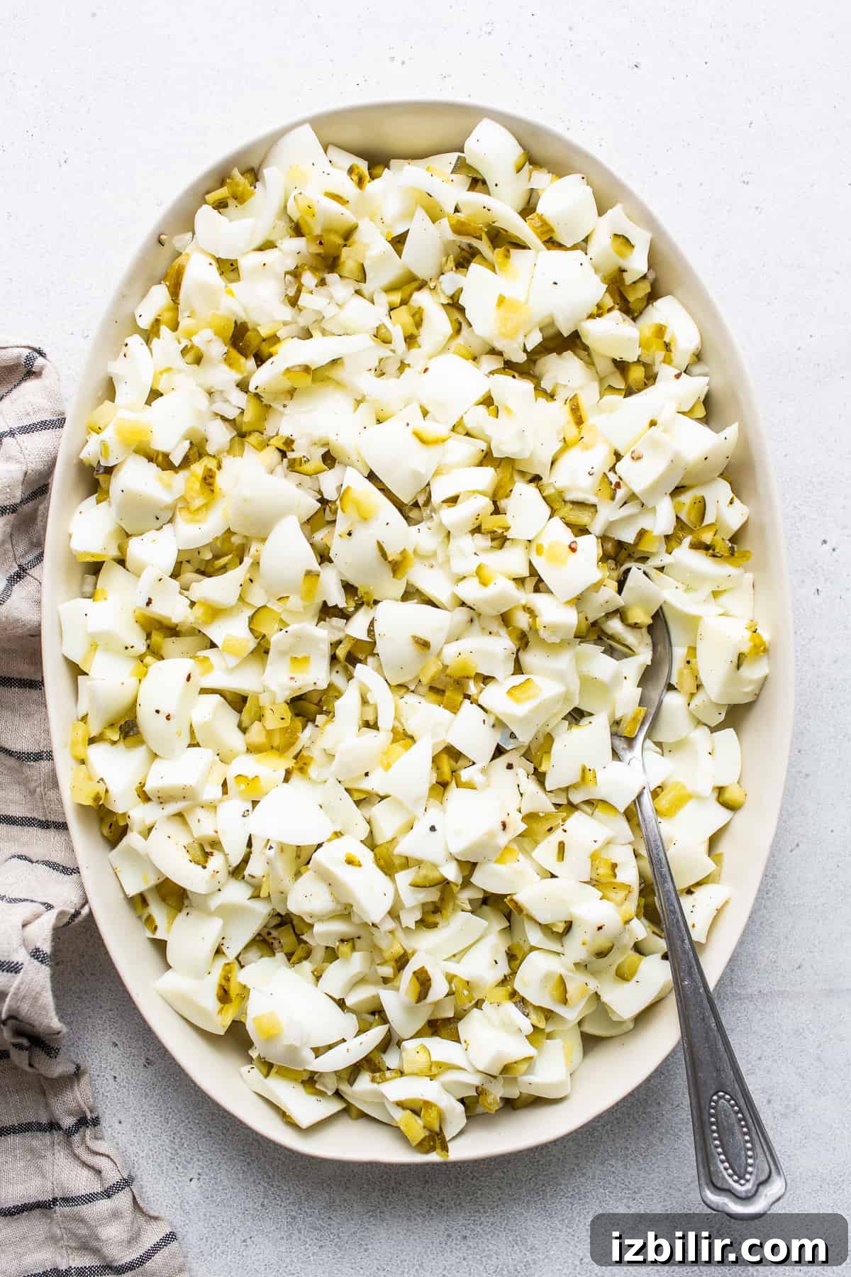 Chopped egg whites in a bowl with a spoon.