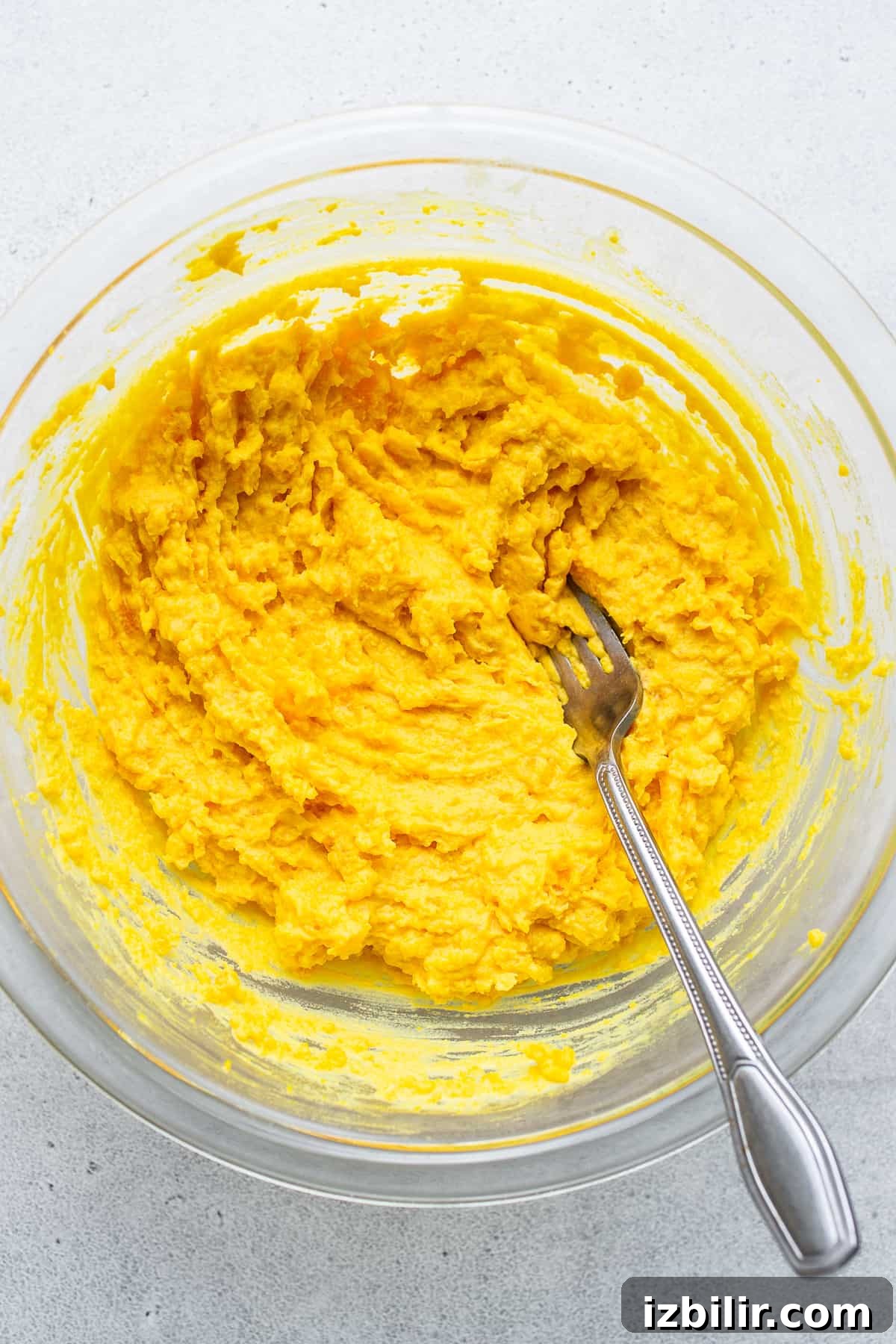 Egg yolks mixed in a bowl with a fork.