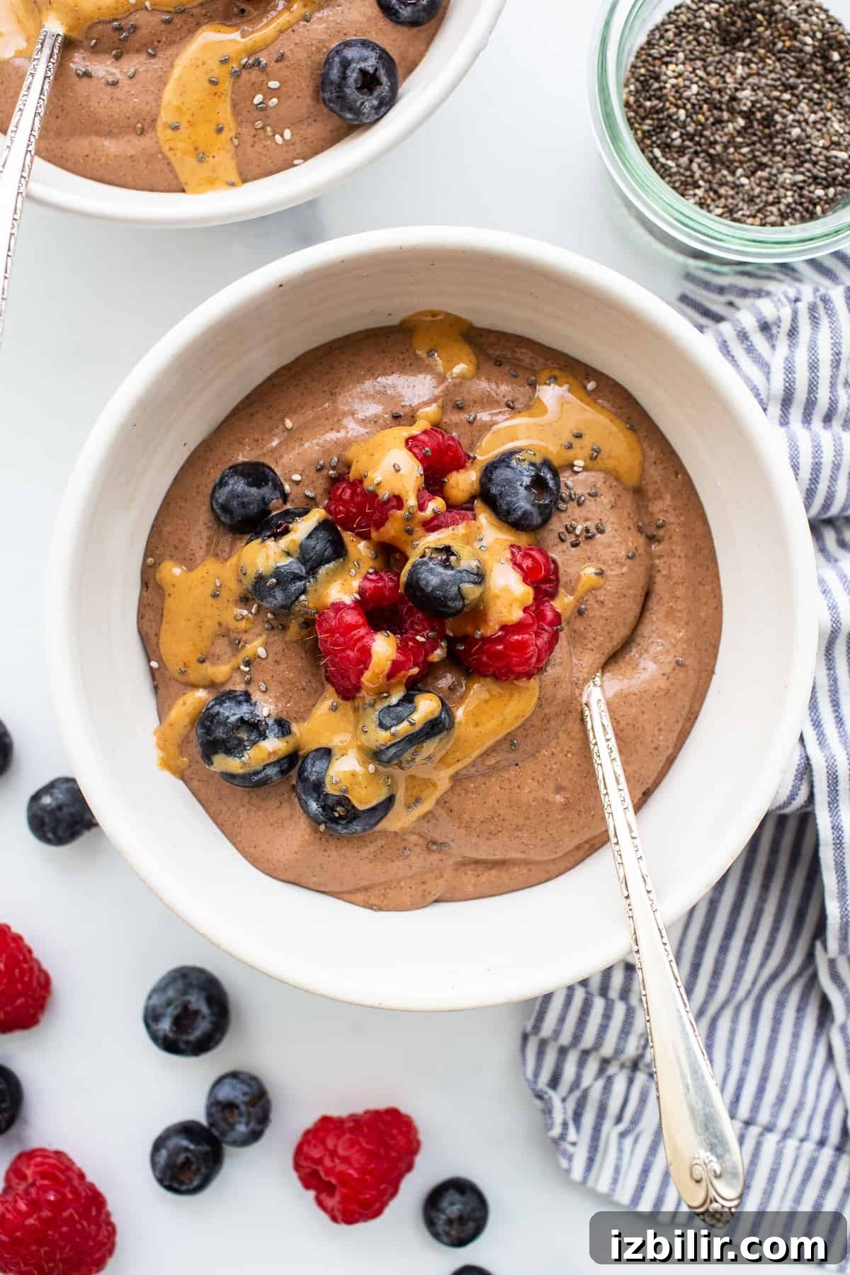 Blended chia seed pudding in a bowl topped with berries and peanut butter.