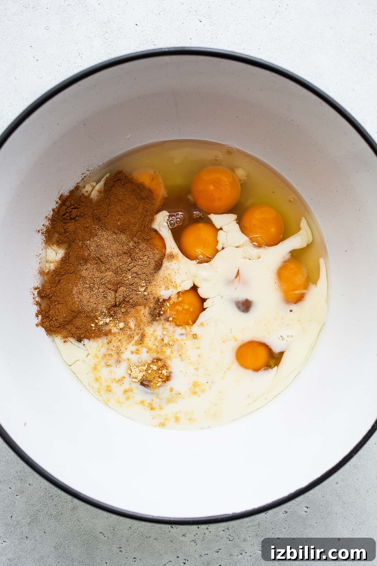 Eggs, milk and cinnamon in a bowl for carrot cake french toast casserole.