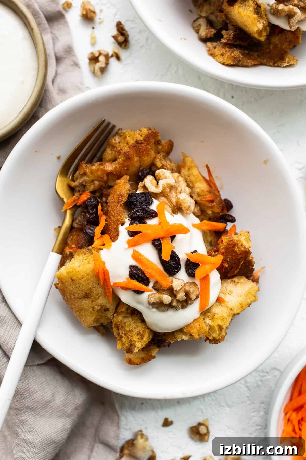 Serving of carrot cake french toast casserole on a plate with a fork.