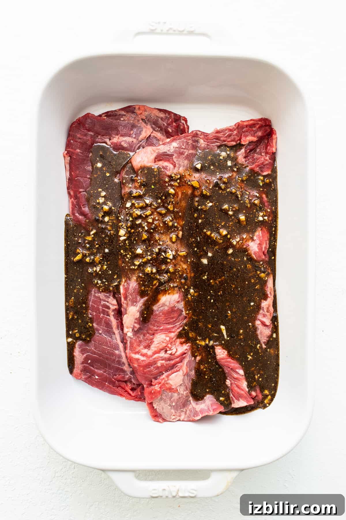 Skirt steak marinating Skirt steak in a dish topped with marinade.