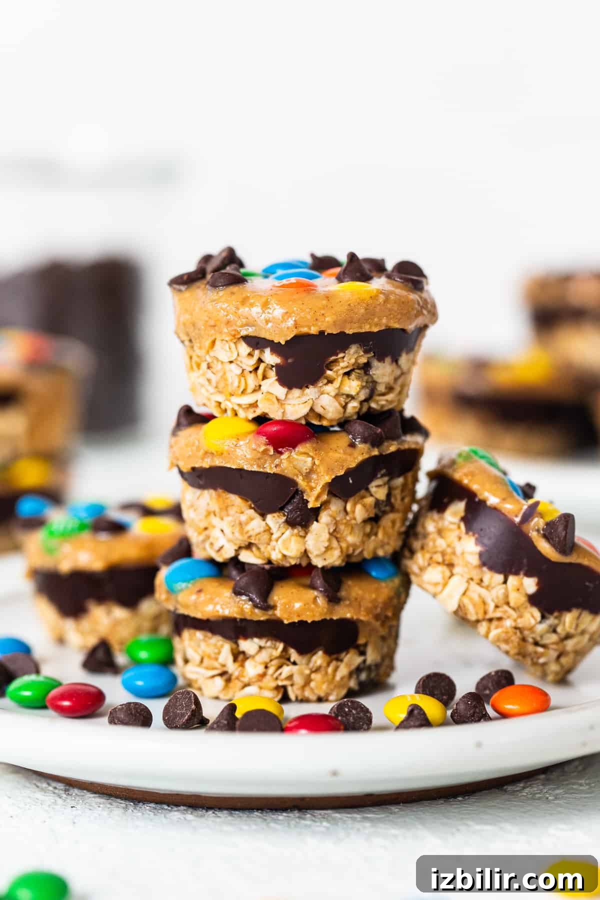 No-Bake Monster Cookie Oat Cups with Peanut Butter & M&Ms 2 Monster cookie oat cups stacked on top of each other.