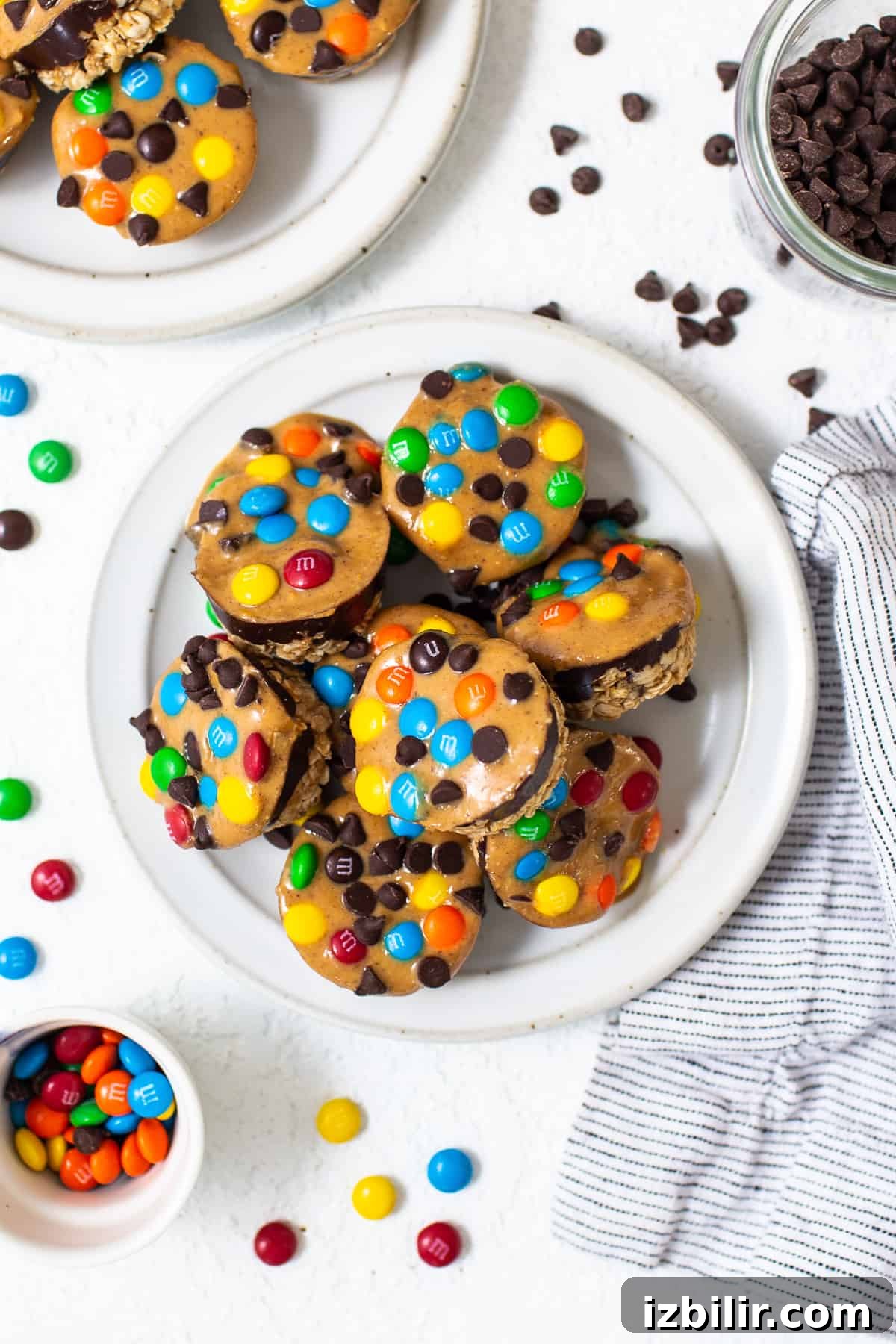 No-Bake Monster Cookie Oat Cups with Peanut Butter & M&Ms 12 Monster cookie oat cups piled on a plate.