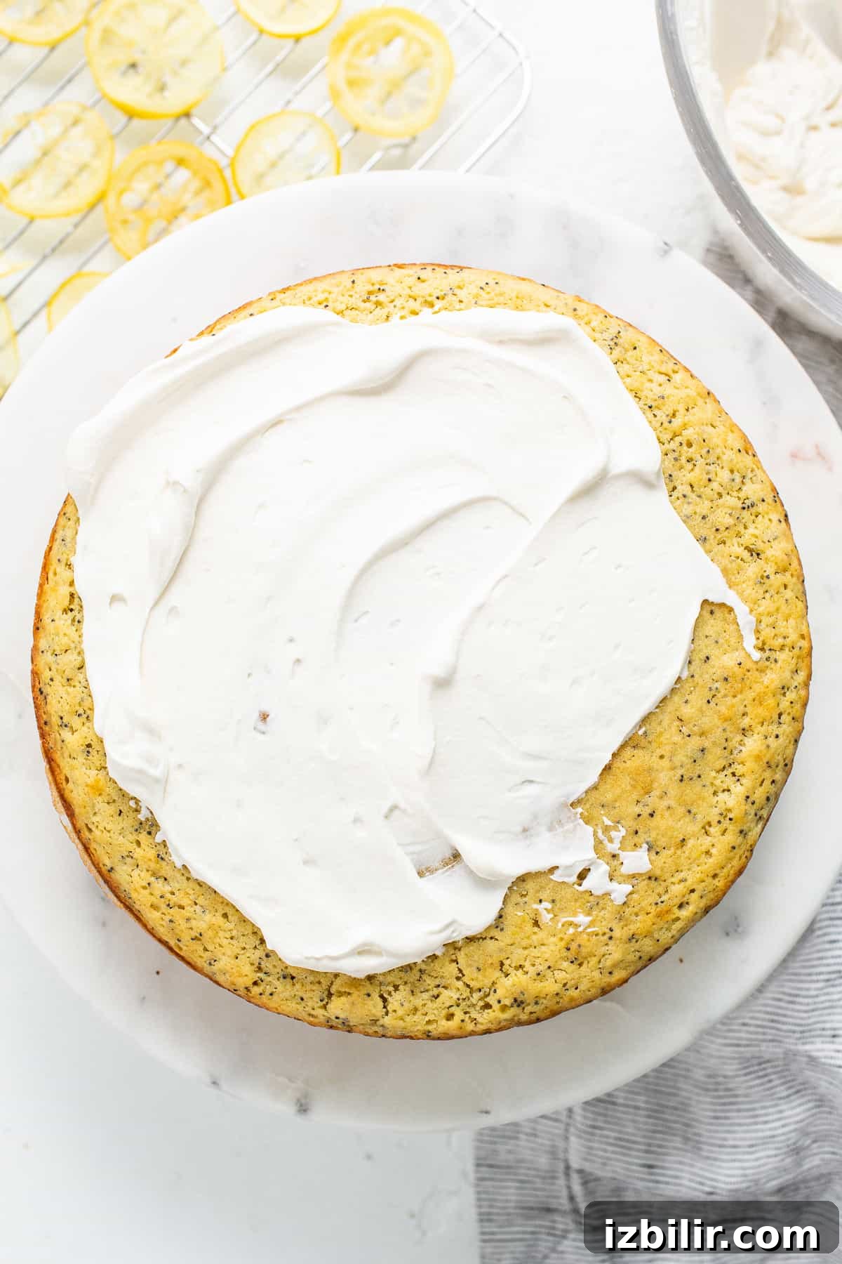 Lemon poppy seed cake topped with whipped cream icing.