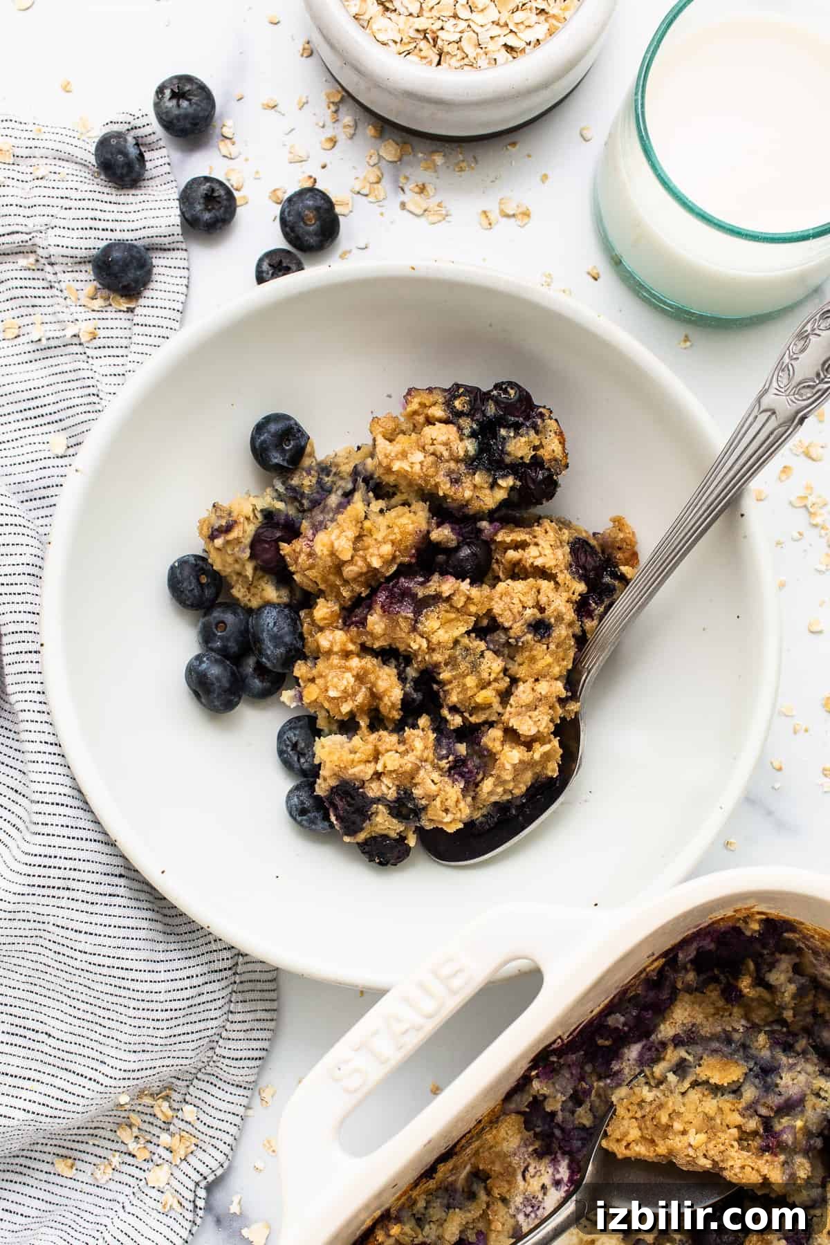 Blueberry muffin baked oatmeal in a bowl with a spoon.