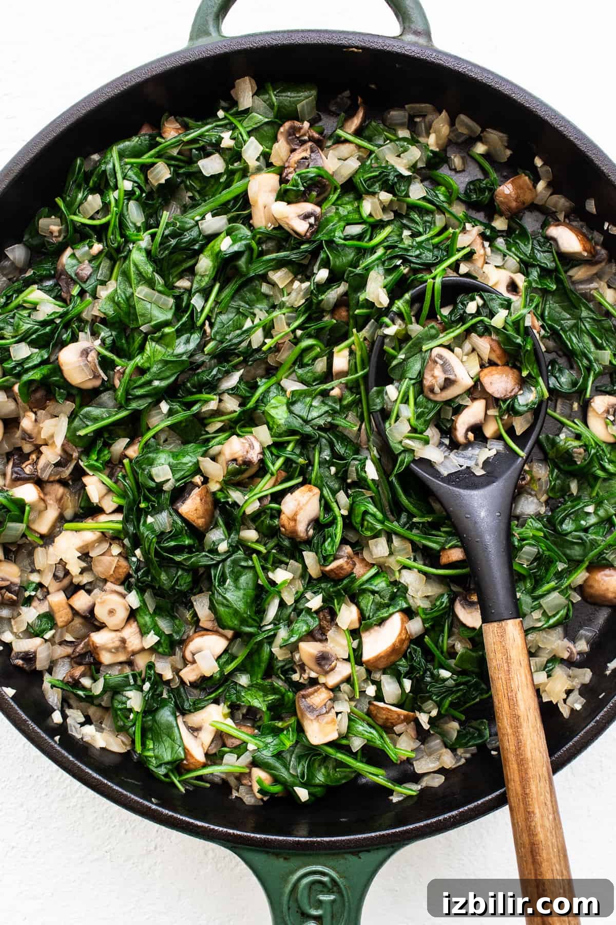 Sauteed spinach and veggies in a pan.