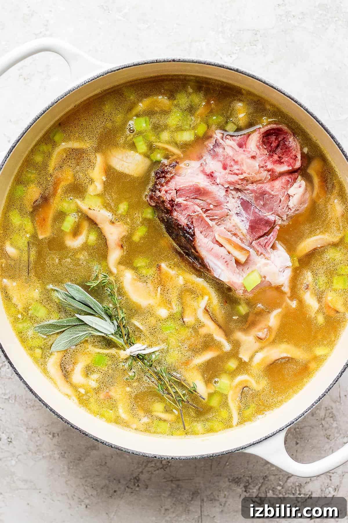 Split pea soup simmering with a ham bone. Split pea soup simmering in a dutch oven with a ham bone.
