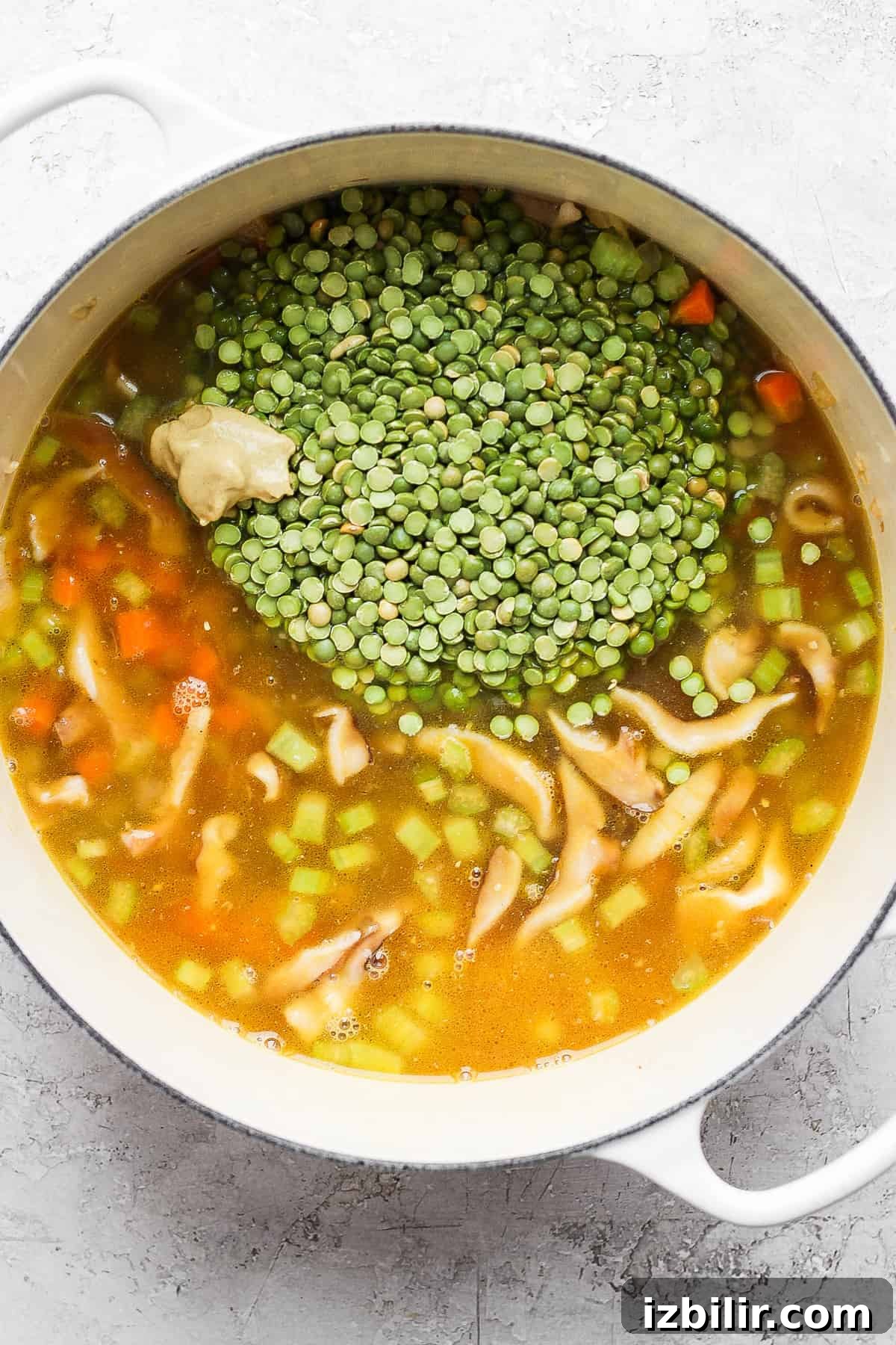 Split peas cooking in broth. Split peas in a dutch oven with soup broth.
