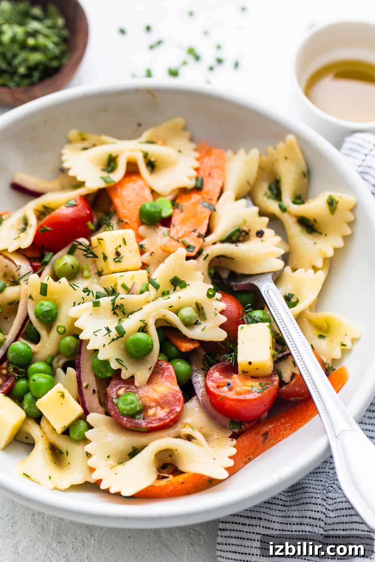 Bow tie pasta salad in a bowl with a fork.