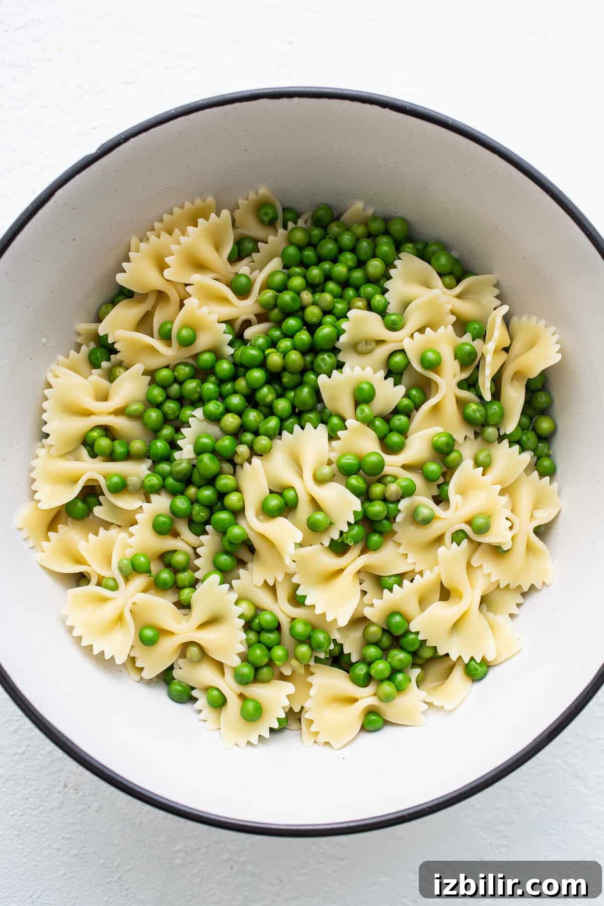 Bow tie pasta and peas in a bowl.
