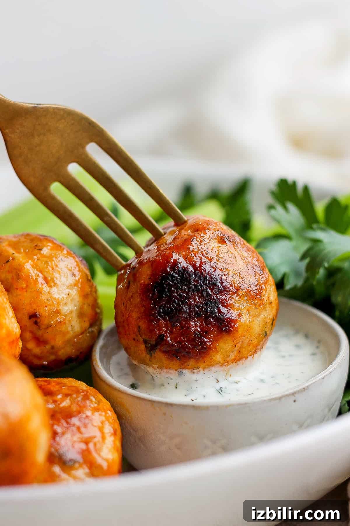 dipping meatball into dressing