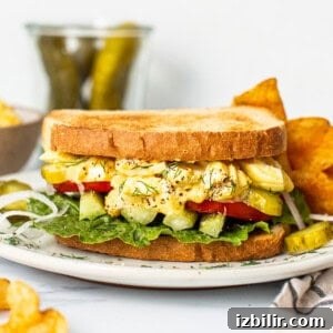 Classic Creamy Egg Salad for Sandwiches and Wraps 3 Egg salad sandwich on a plate.