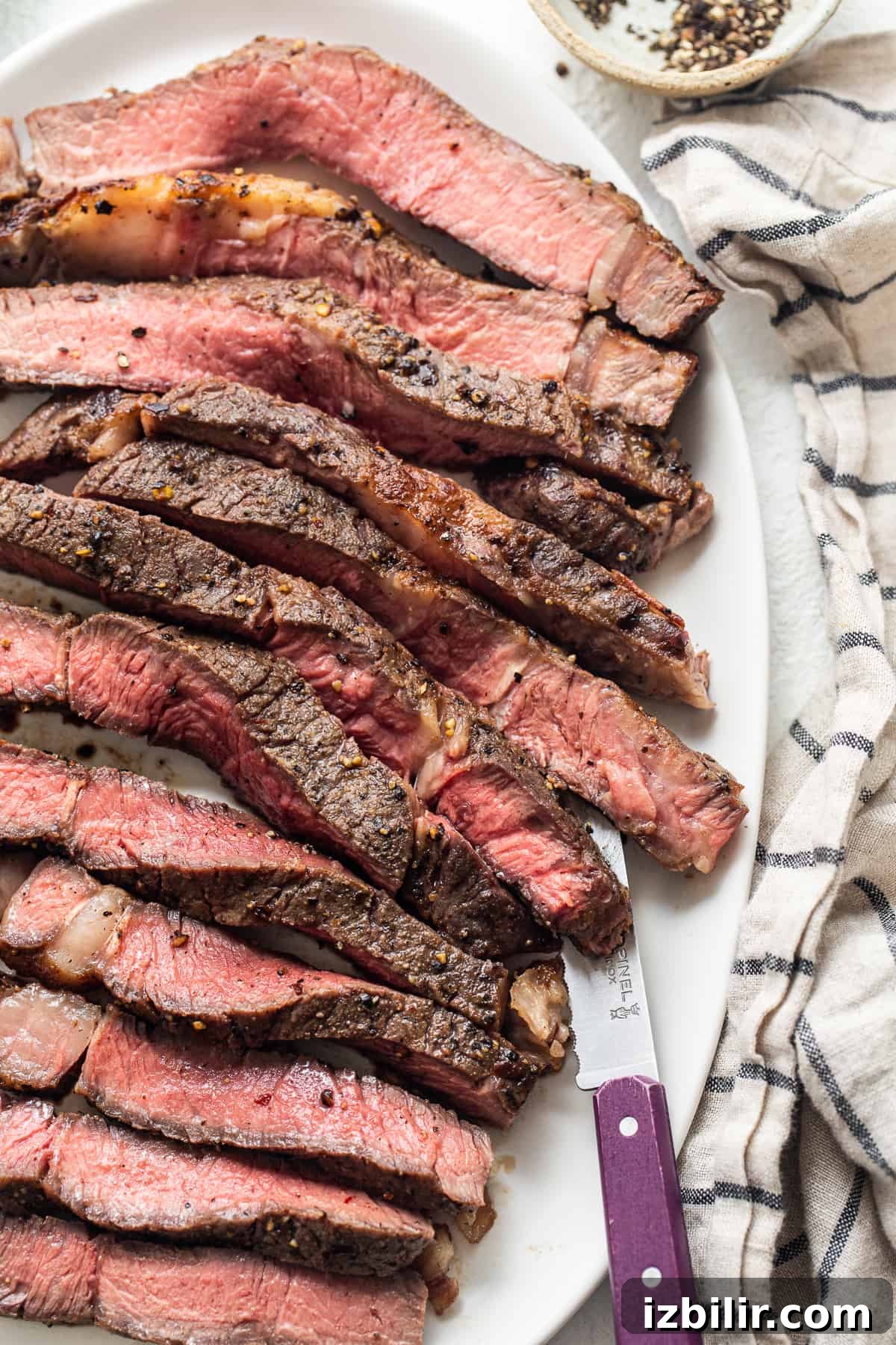 Sliced steak with knife Sliced air fryer steak on a plate with a knife.