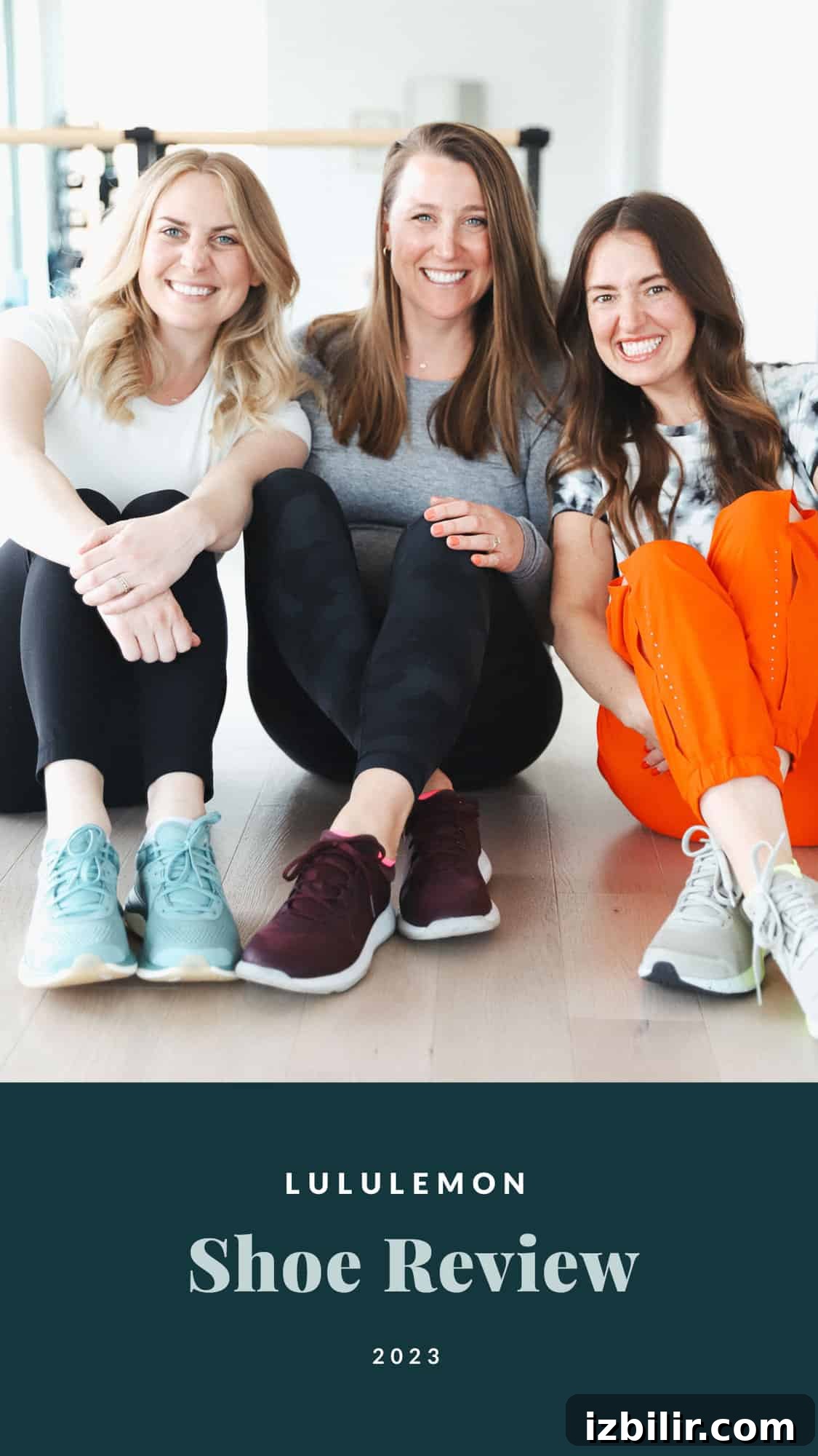 Three women sitting on the floor smiling.
