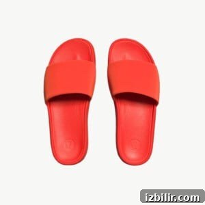 A pair of red slide sandals on a white background.