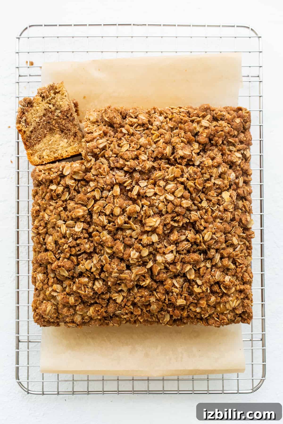 A piece of coffee cake sliced and cooling on a wire rack.