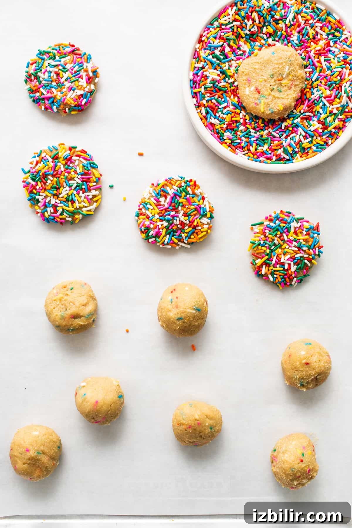Dipping cookie dough into sprinkles. dipping cookies in sprinkles.