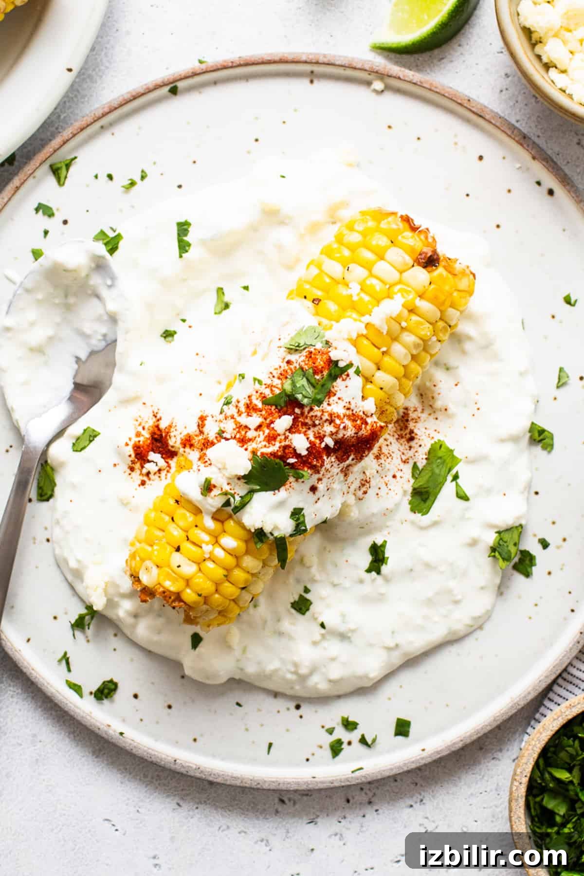 Air fryer elote on a plate with a spoon.