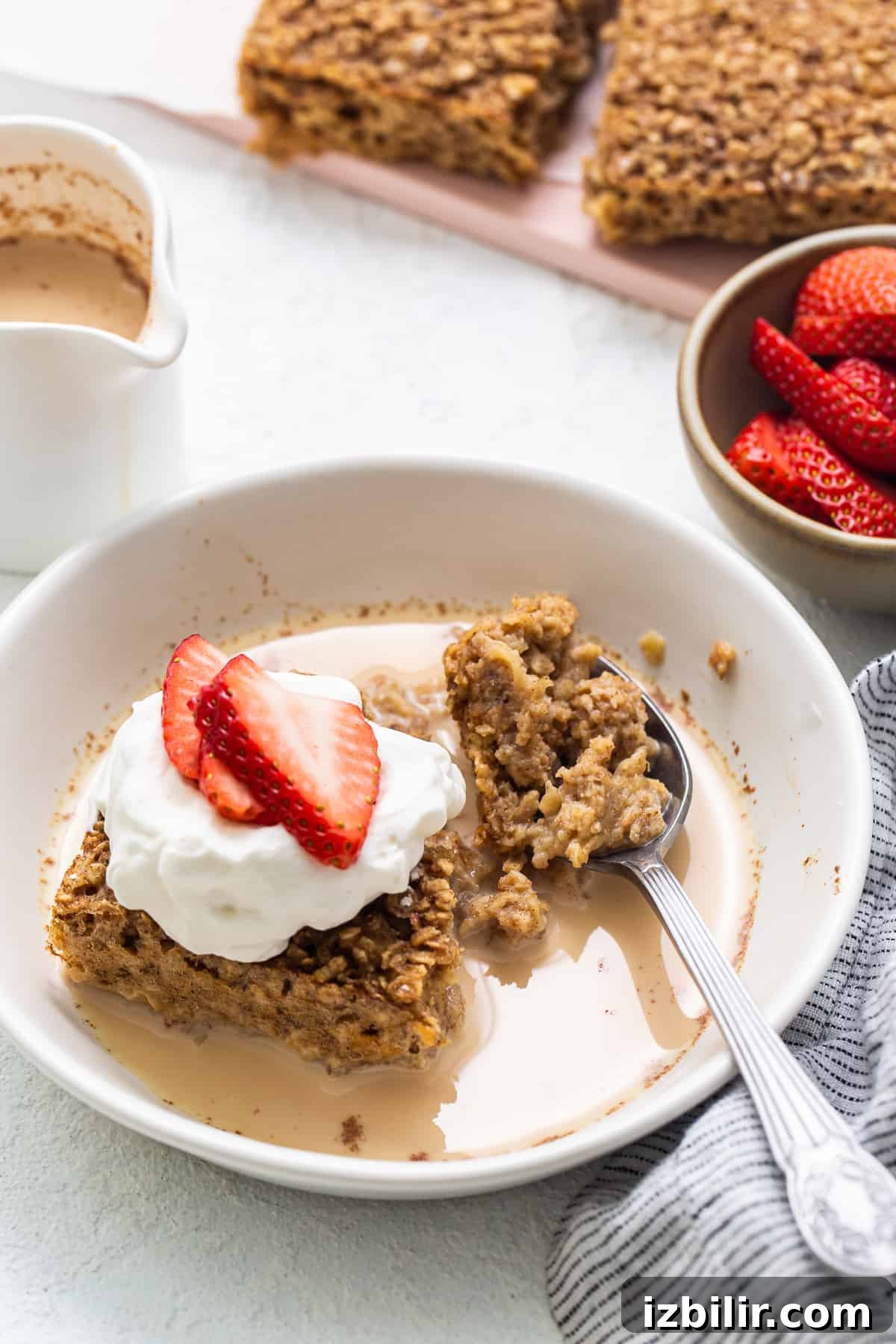 Tres Leches Baked Oatmeal with Whipped Cream Slice of tres leches baked oatmeal topped with whipped cream and strawberries.