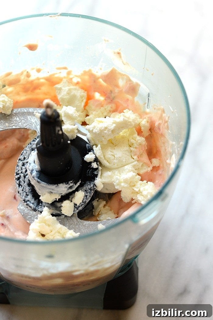 With Sunday football back in action, this Skinny Roasted Red Pepper and Goat Cheese Dip makes for the most perfect appetizer. It's made with a non-fat Greek yogurt base, pureed roasted red peppers, and goat cheese!