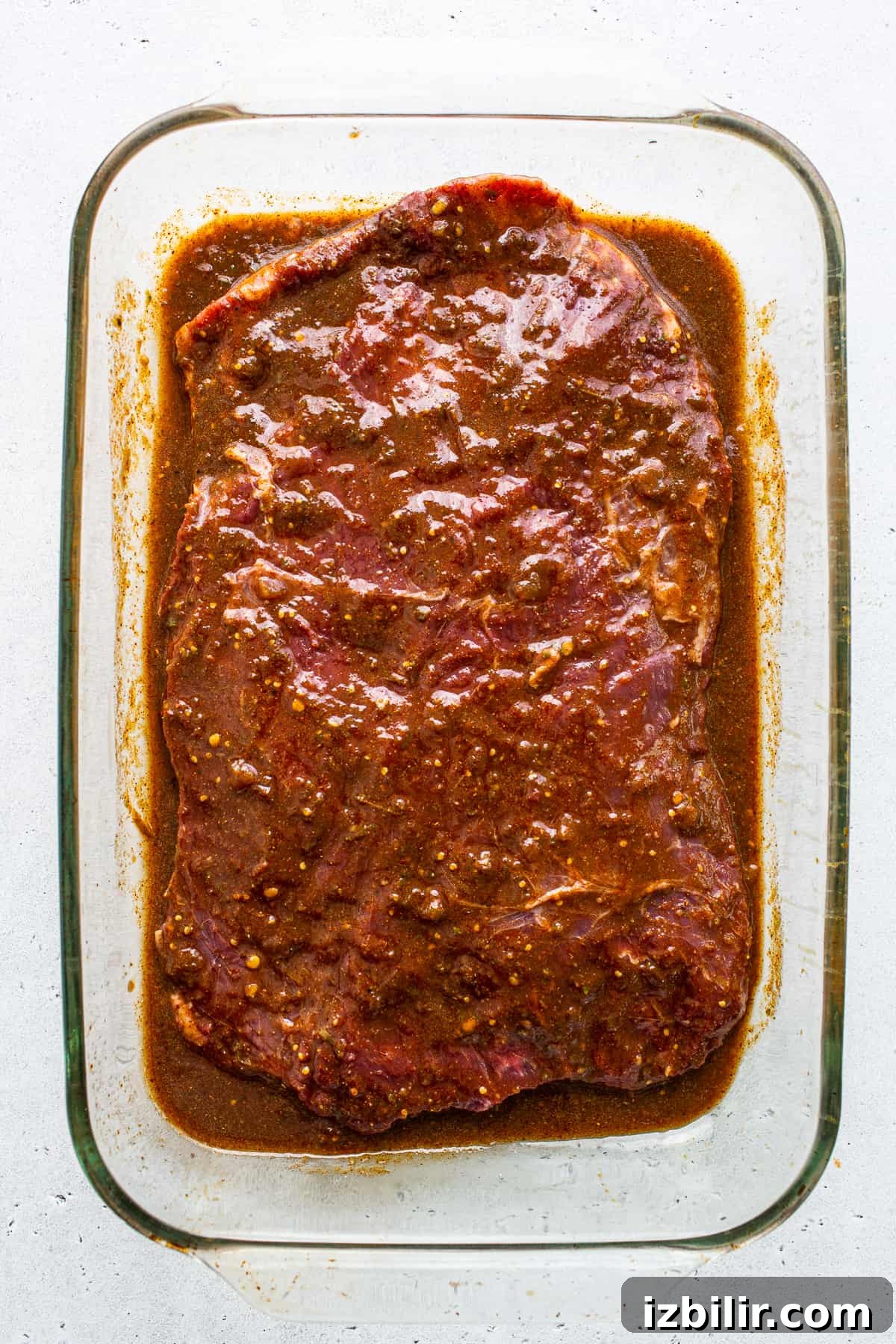 Flank steak marinating in a glass dish. Flank steak marinating in a glass dish.