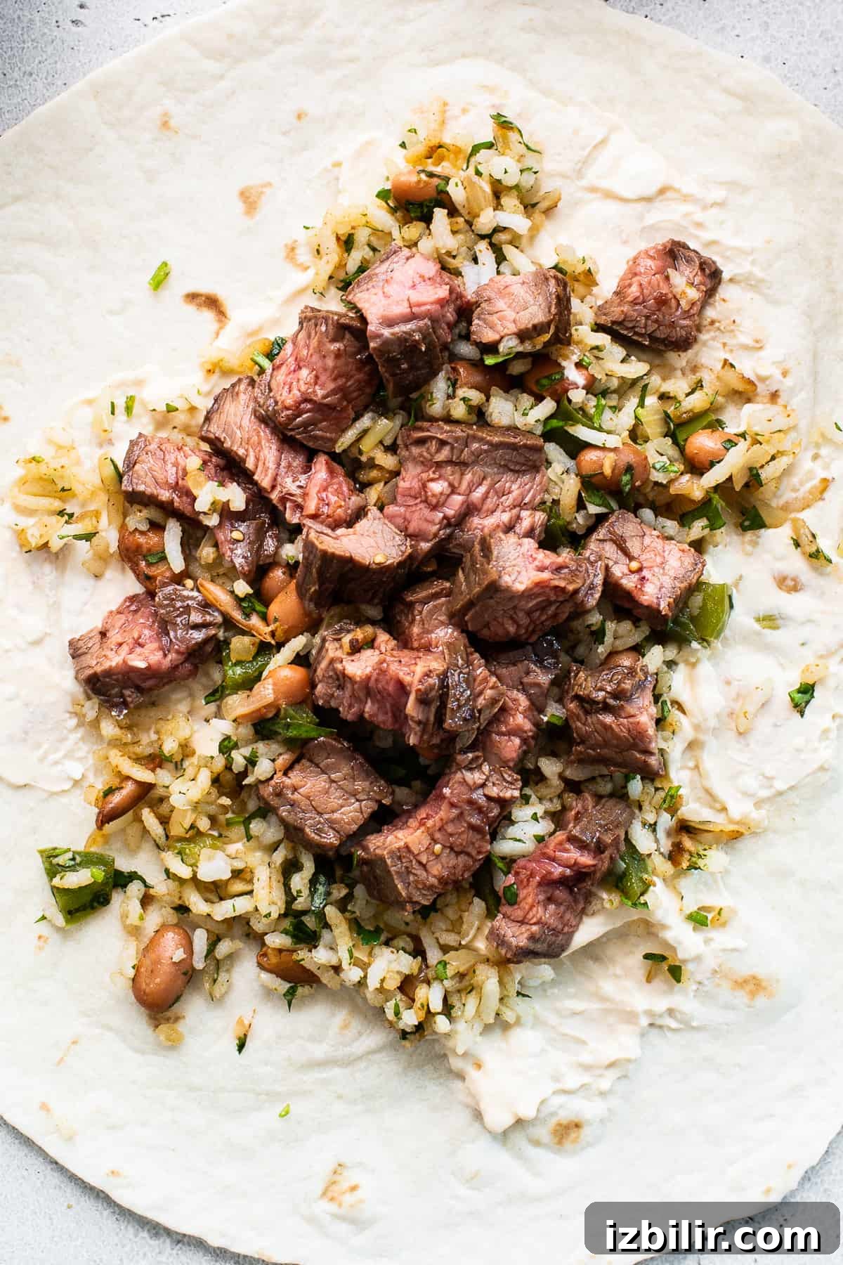 Diced steak on a tortilla with rice.
