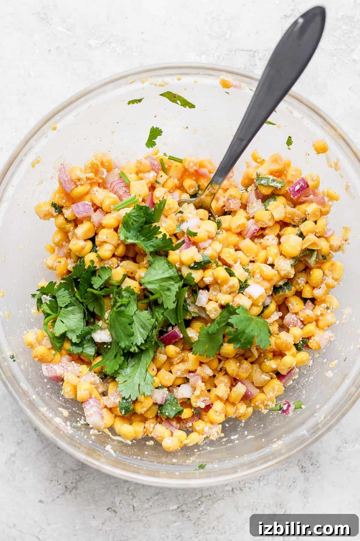 Slow Cooker Carnitas Burrito Bowls with Cilantro Lime Rice 7 Mexican corn salad with slow cooker carnitas served in a glass bowl.