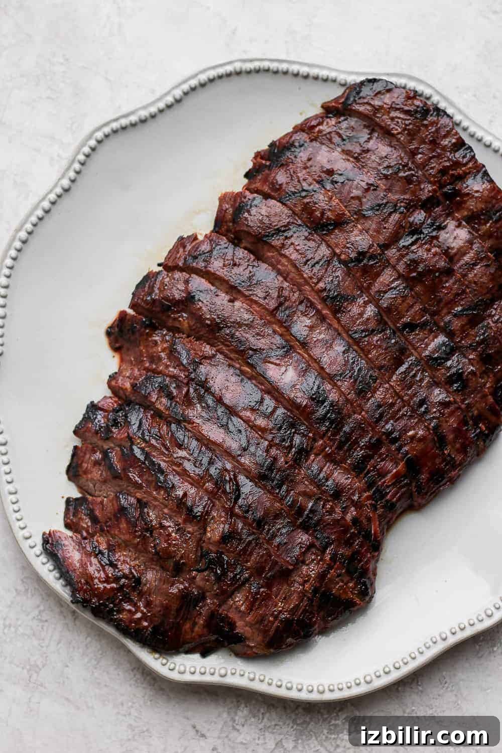 Flank Steak Marinade for Grilling and Searing 2 Sliced flank steak on a plate.