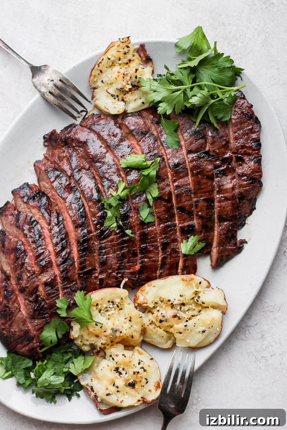 Flank Steak Marinade for Grilling and Searing 6 Flank steak on a plate with a fork.