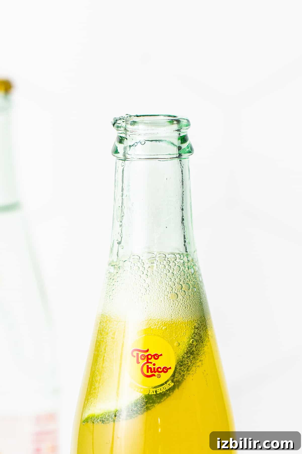 Bottle of topo chico with ranch water and a slice of lime in it.