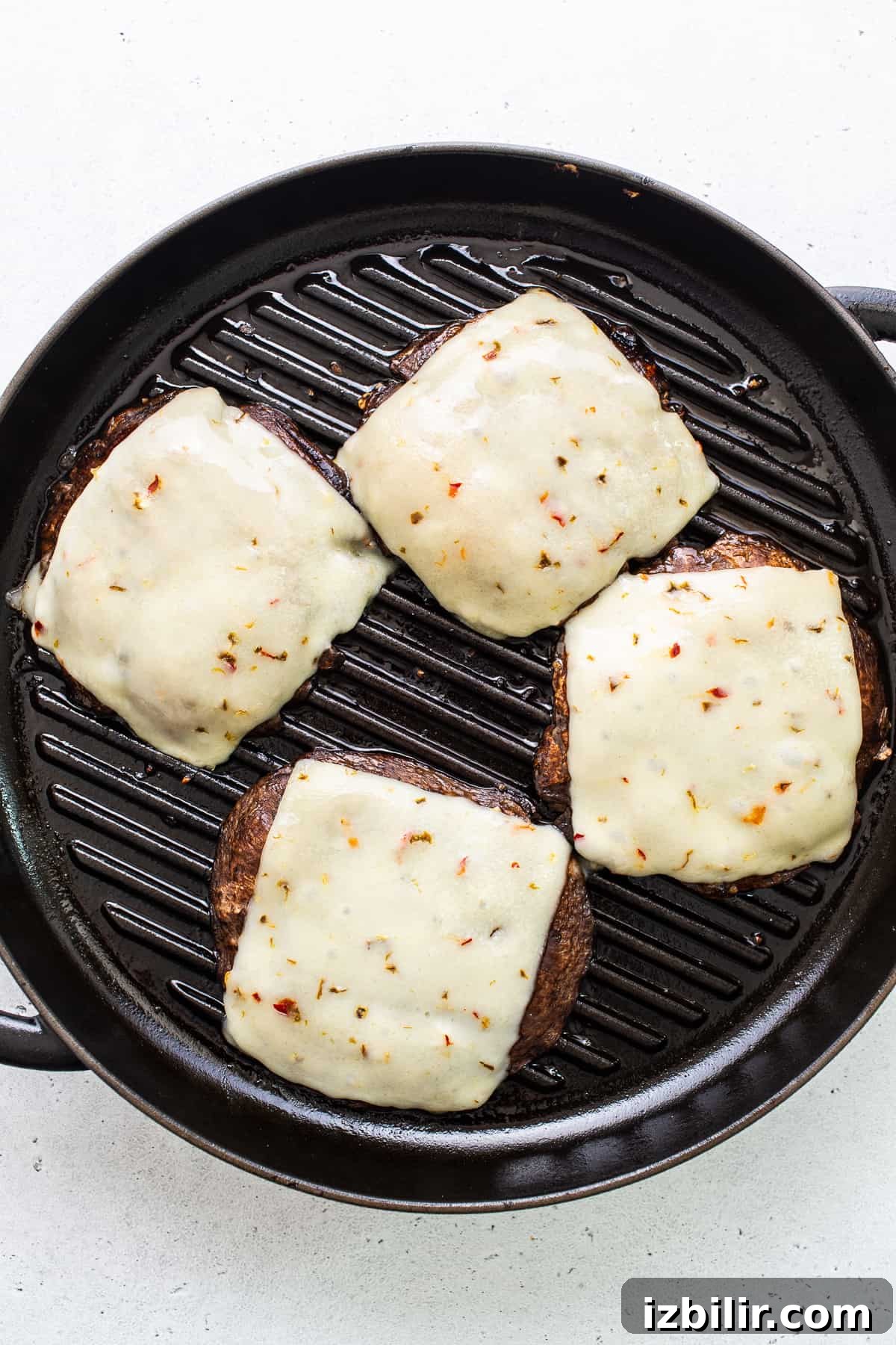 Cheesy portobello caps. Portobello mushroom burgers topped with cheese in a grill pan.