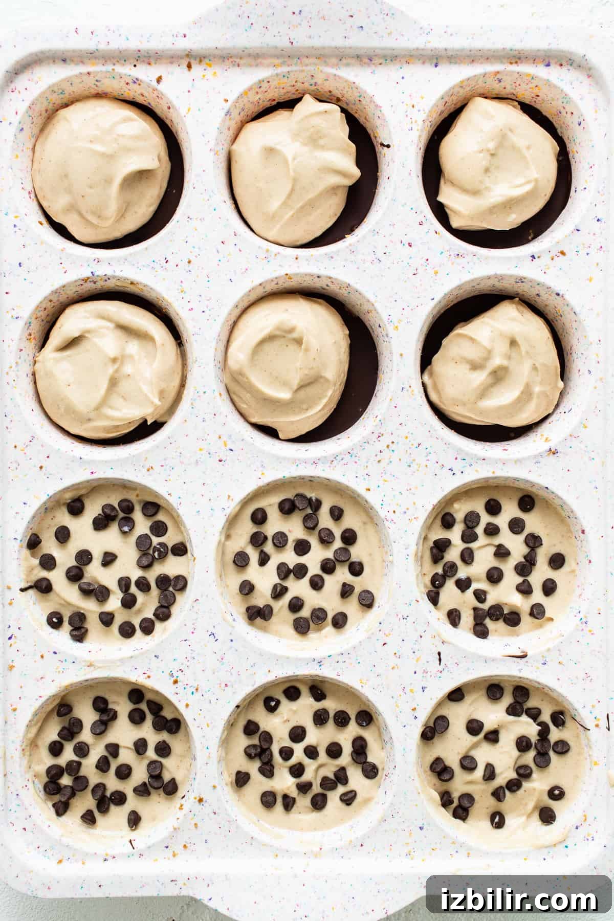 Cheesecake cups in muffin tin Peanut butter chocolate cheesecake cups in a muffin tin.