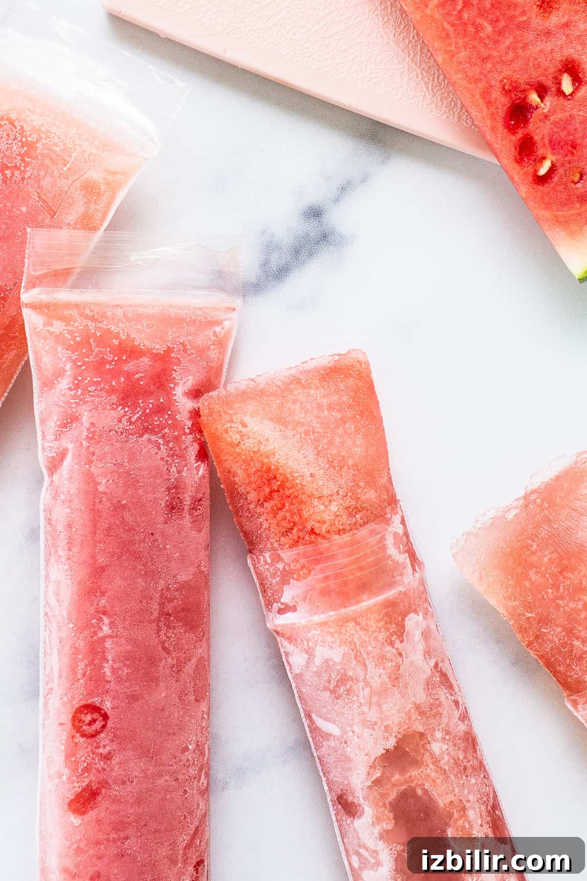 Watermelon wine freeze pops on a counter.