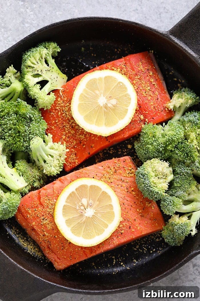 Lemon wedges on seasoned salmon before baking
