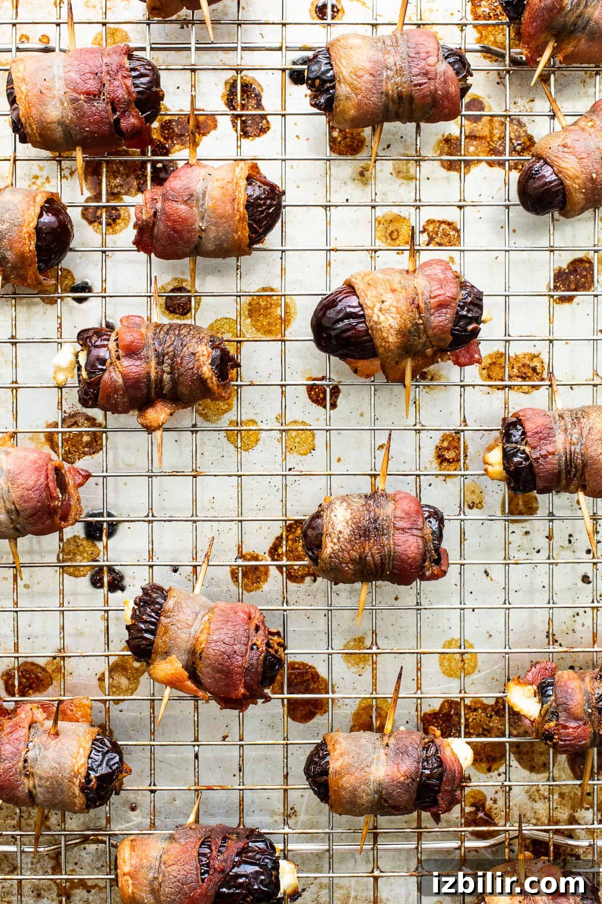 Bacon wrapped dates on baking sheet Bacon wrapped dates with goat cheese on a baking sheet.