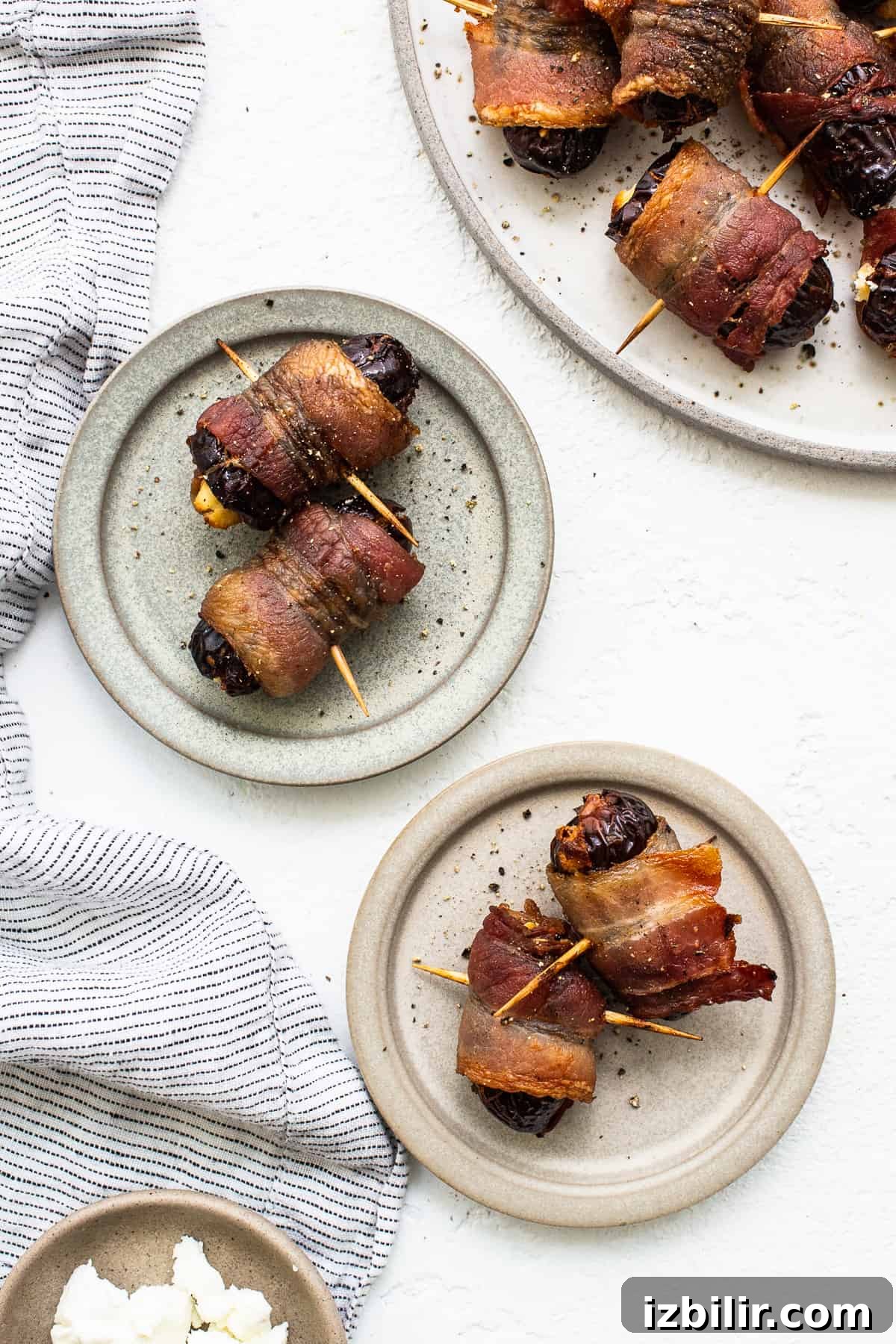 Bacon wrapped dates plated Bacon wrapped dates with goat cheese on a plate.