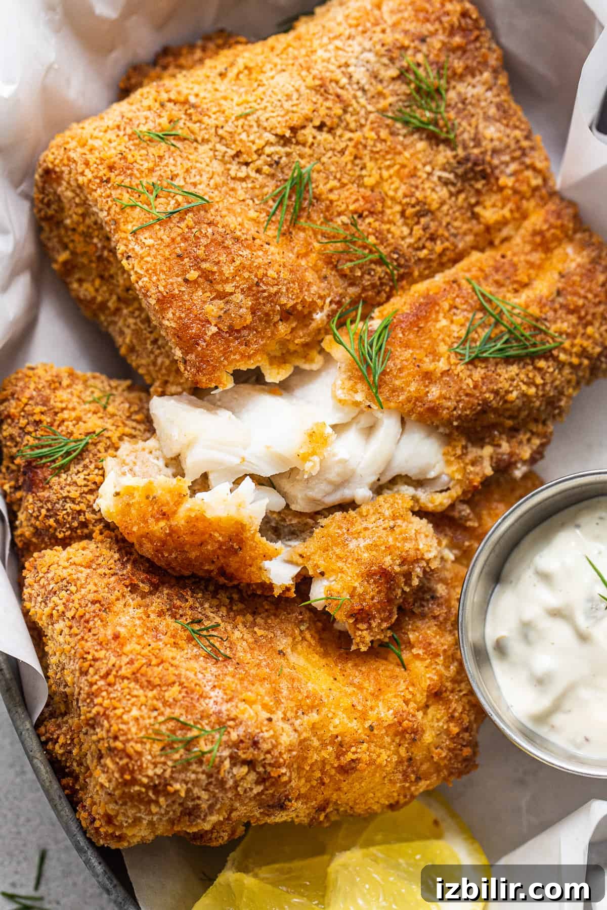 Flaky air fryer fish with tartar sauce.