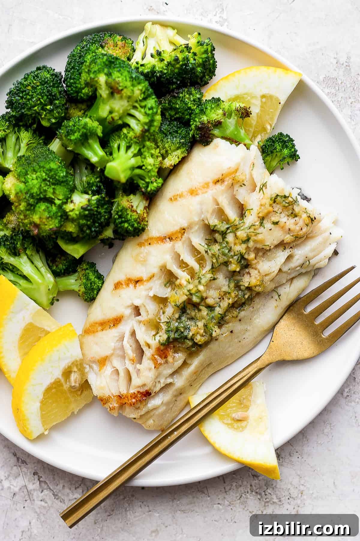 Grilled fish on a plate with broccoli.