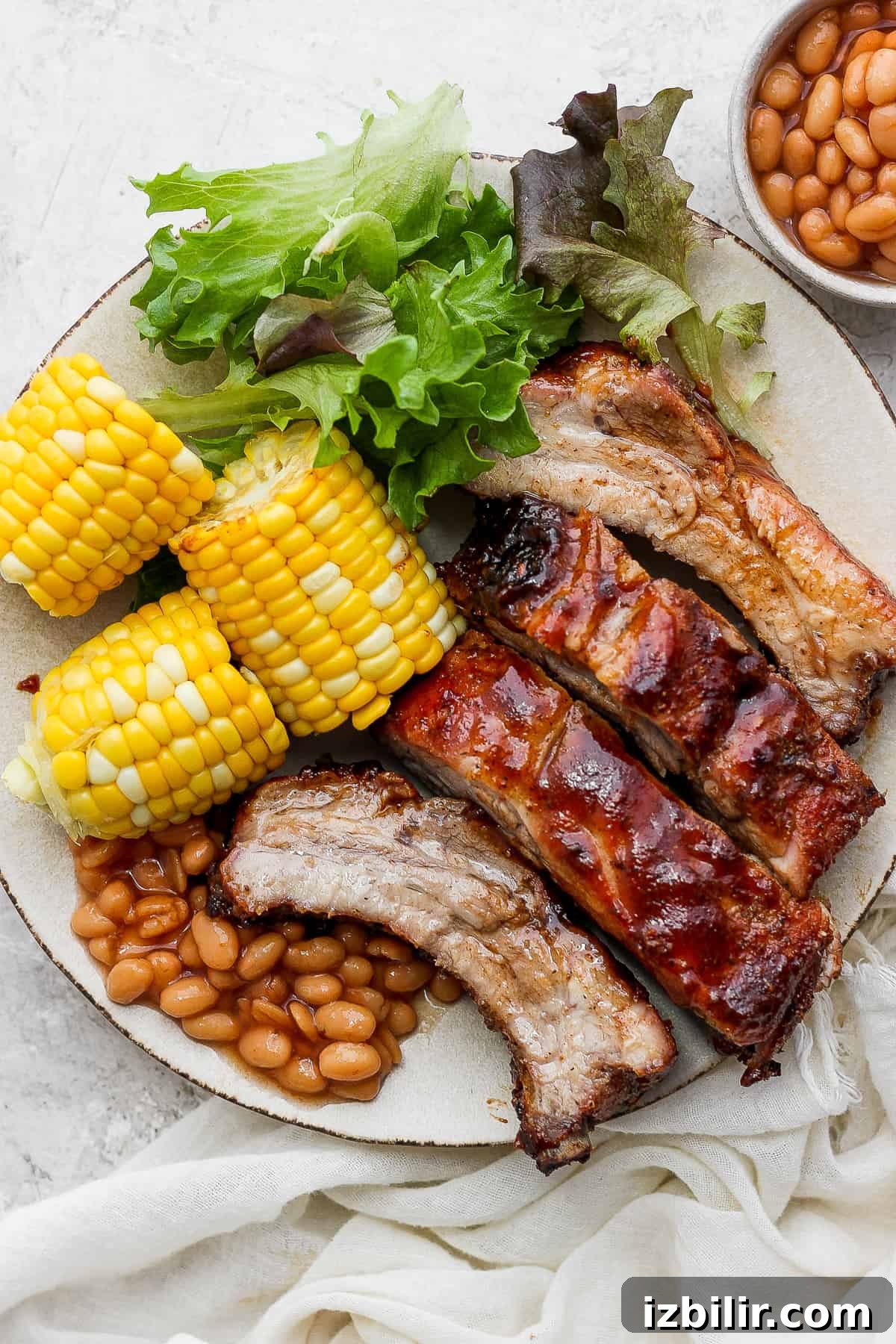 Foolproof Baby Back Ribs: Grill or Oven Recipe 2 A plate with ribs, corn, beans, and lettuce.