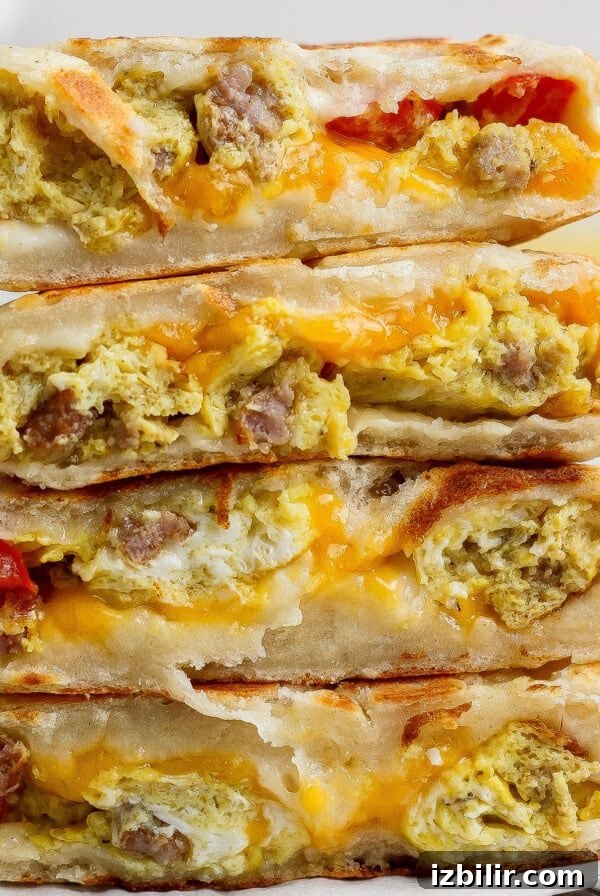 A stack of four breakfast quesadillas filled with scrambled eggs and sausage.
