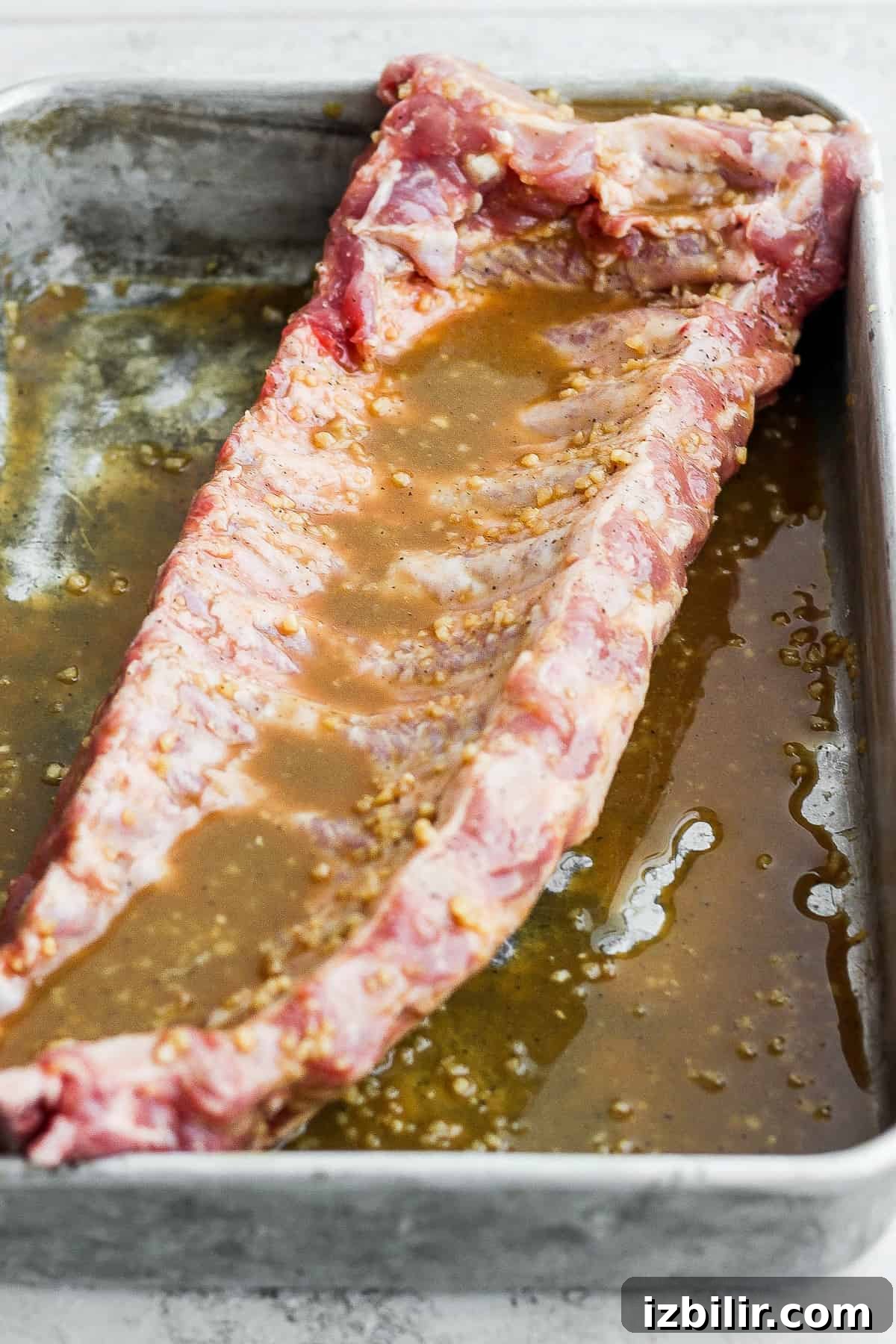 Rack of baby back ribs being marinated.