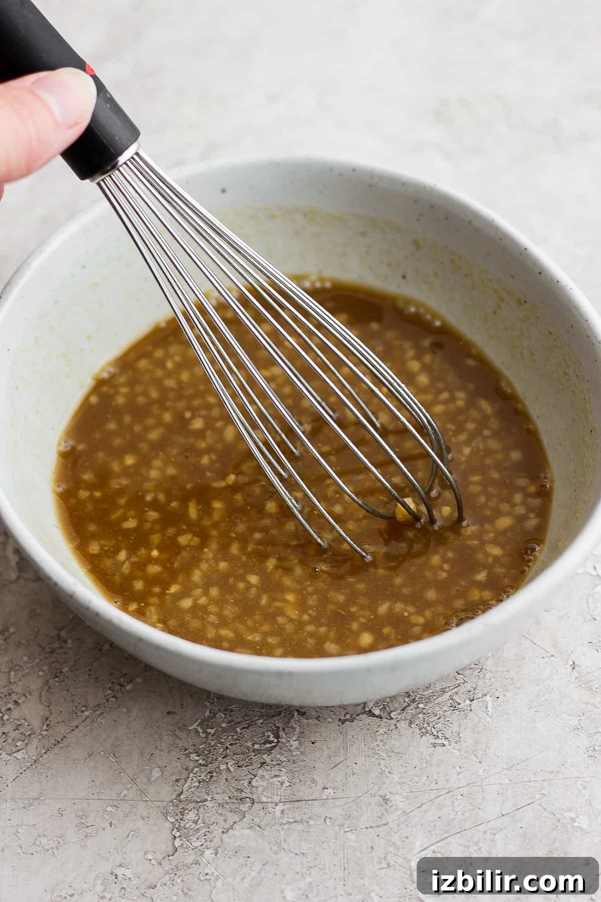 Rib marinade in a bowl with a whisk.
